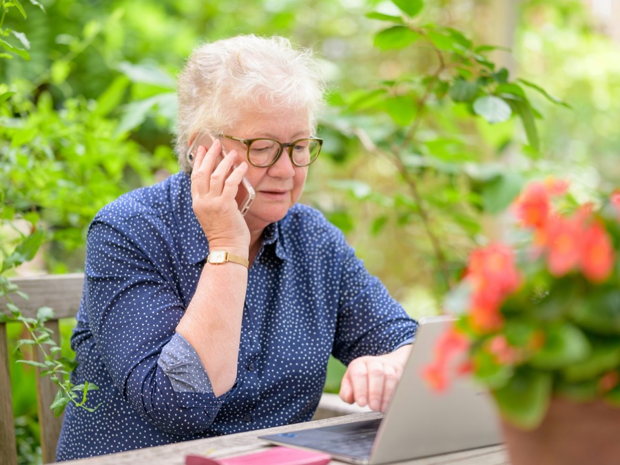 Senior using a laptop and phone