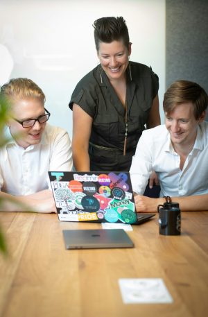 Coworkers gathered around a laptop reviewing work together